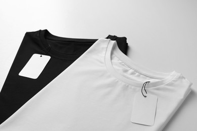 Photo of Different blank t-shirts on white background, closeup. Mockup for design