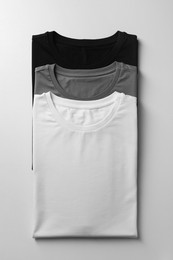 Photo of Different blank t-shirts on white background, top view. Mockup for design