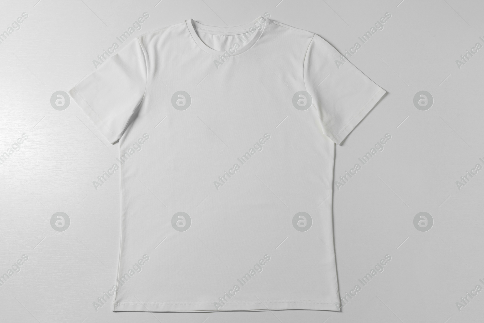 Photo of One blank t-shirt on white background, top view. Mockup for design