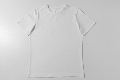 Photo of One blank t-shirt on white background, top view. Mockup for design