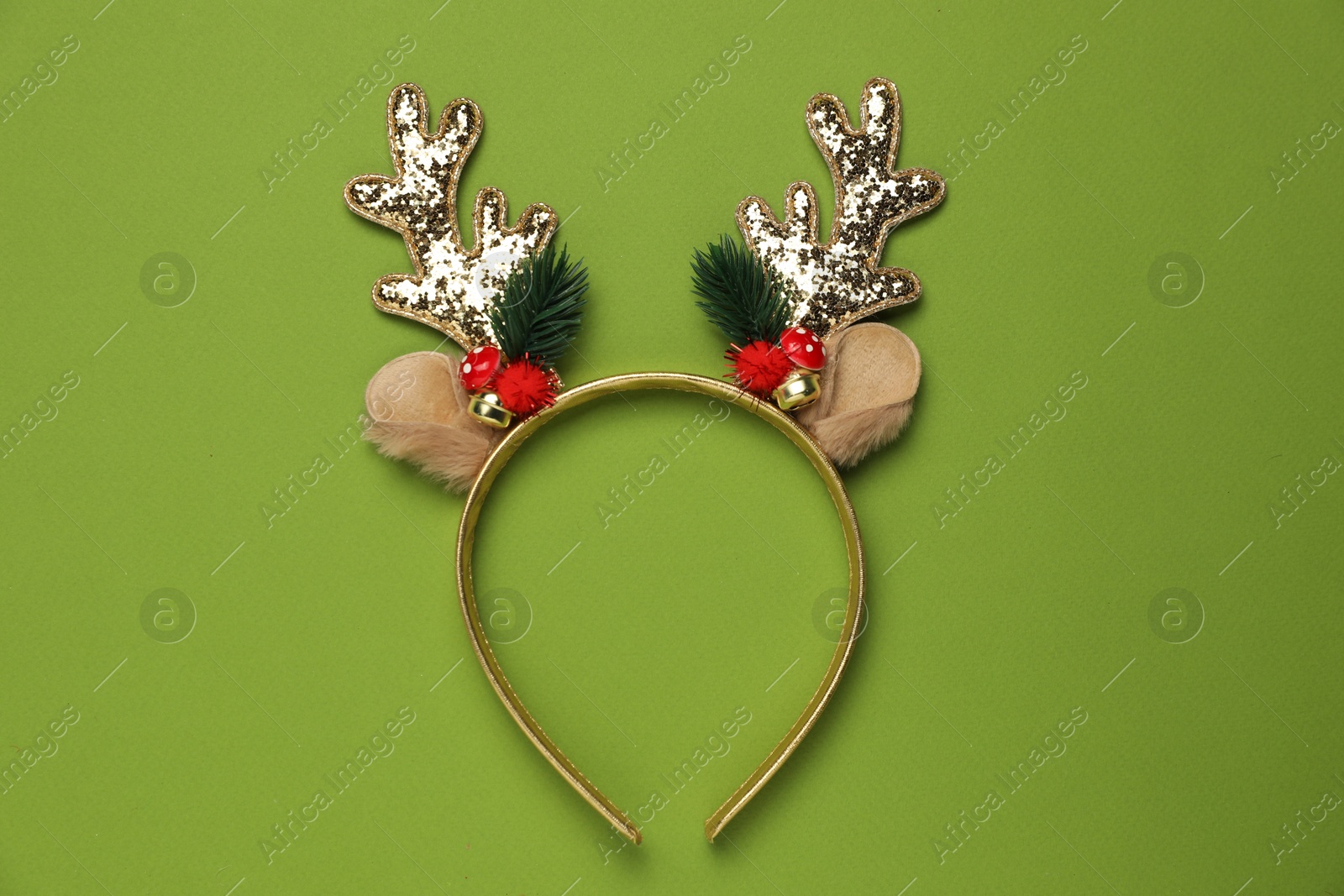 Photo of Beautiful reindeer headband on green background, top view. Christmas accessory