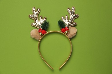 Beautiful reindeer headband on green background, top view. Christmas accessory