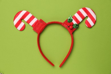 Photo of Stylish party headband on green background, top view. Christmas accessory