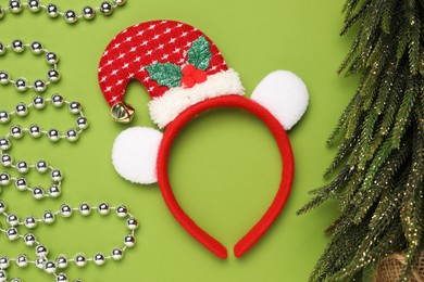 Photo of Stylish party headband and Christmas decor on green background, flat lay