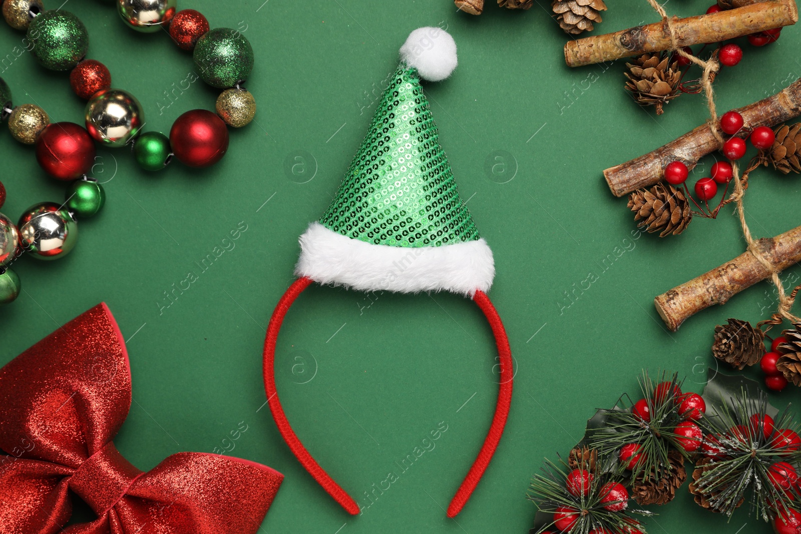 Photo of Stylish party headband and Christmas decor on green background, flat lay