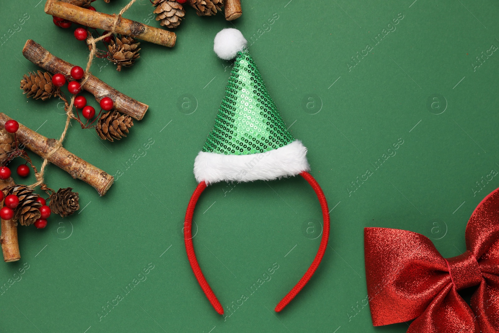 Photo of Stylish party headband and Christmas decor on green background, flat lay