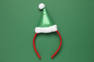 Photo of Stylish party headband on green background, top view. Christmas accessory