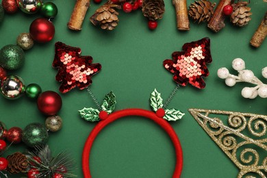 Photo of Stylish party headband and Christmas decor on green background, flat lay