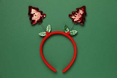 Stylish party headband on green background, top view. Christmas accessory