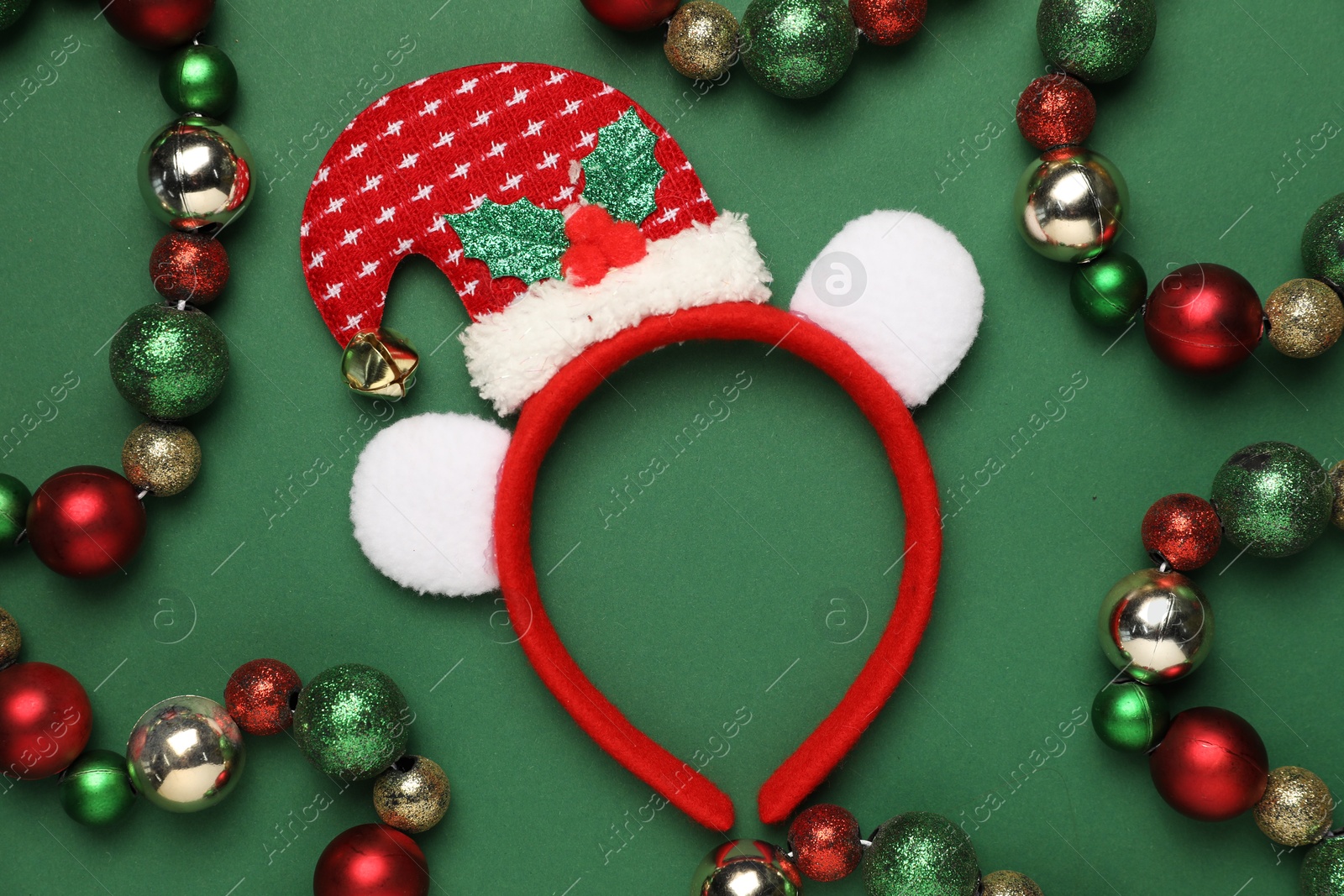 Photo of Stylish party headband and Christmas decor on green background, flat lay