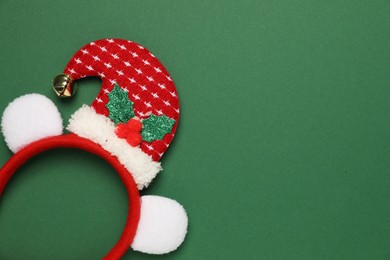 Stylish party headband on green background, top view with space for text. Christmas accessory