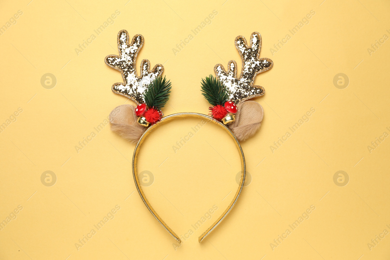 Photo of Beautiful reindeer headband on pale yellow background, top view. Christmas accessory