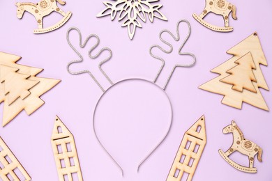 Photo of Beautiful reindeer headband and Christmas decor on lilac background, flat lay