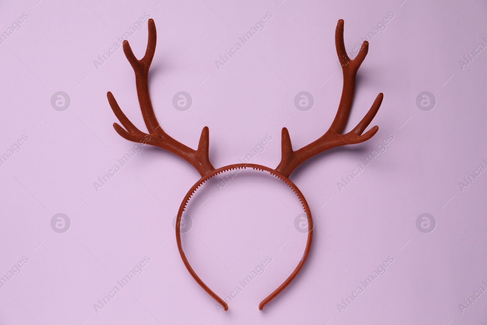 Photo of Beautiful reindeer headband on lilac background, top view. Christmas accessory