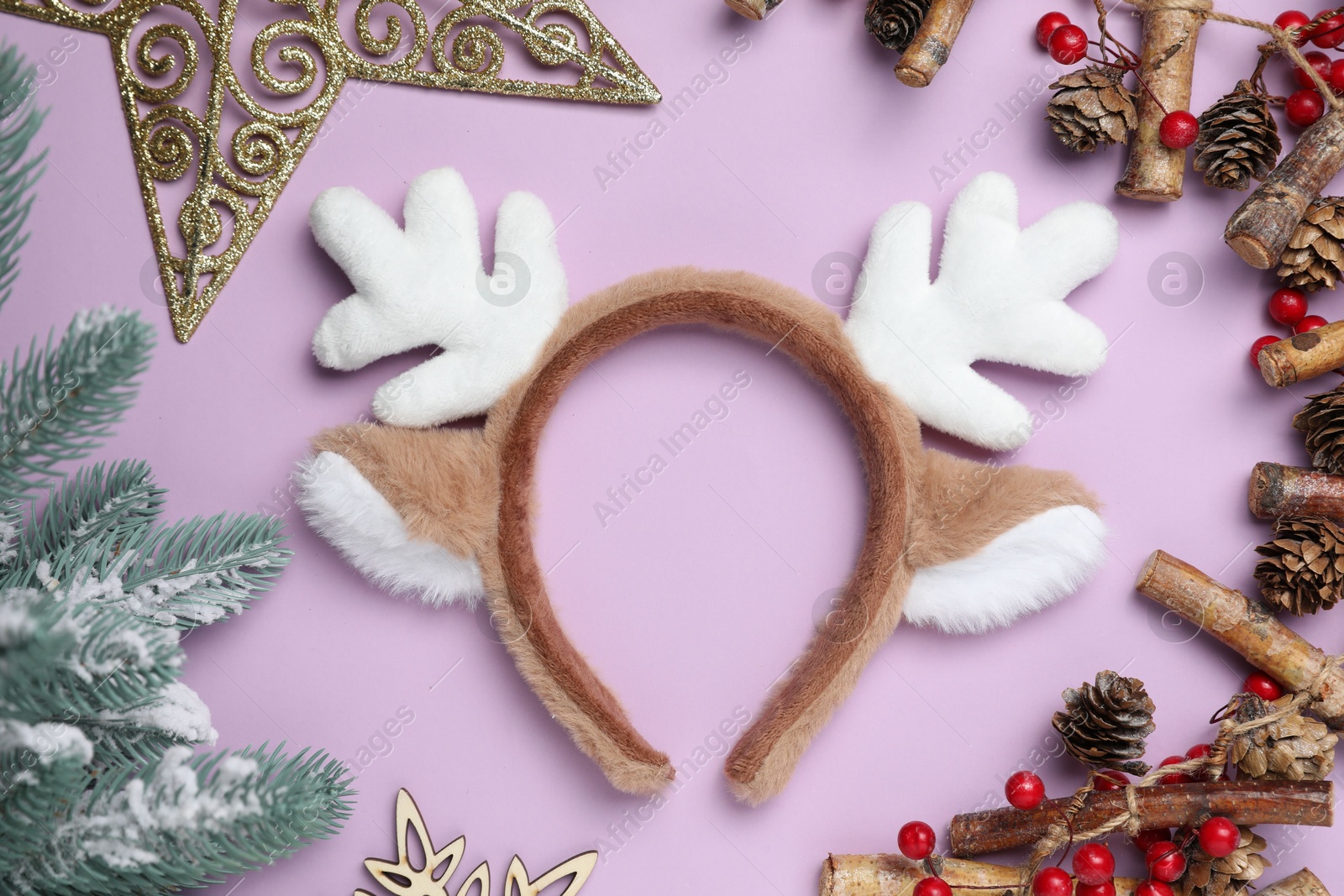 Photo of Beautiful reindeer headband and Christmas decor on lilac background, flat lay