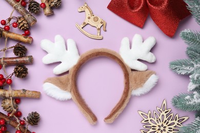 Photo of Beautiful reindeer headband and Christmas decor on lilac background, flat lay