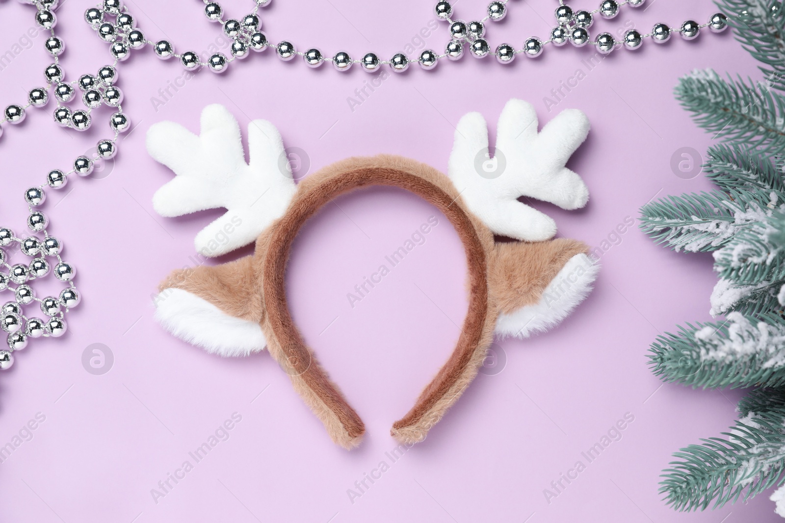 Photo of Beautiful reindeer headband and Christmas decor on lilac background, flat lay