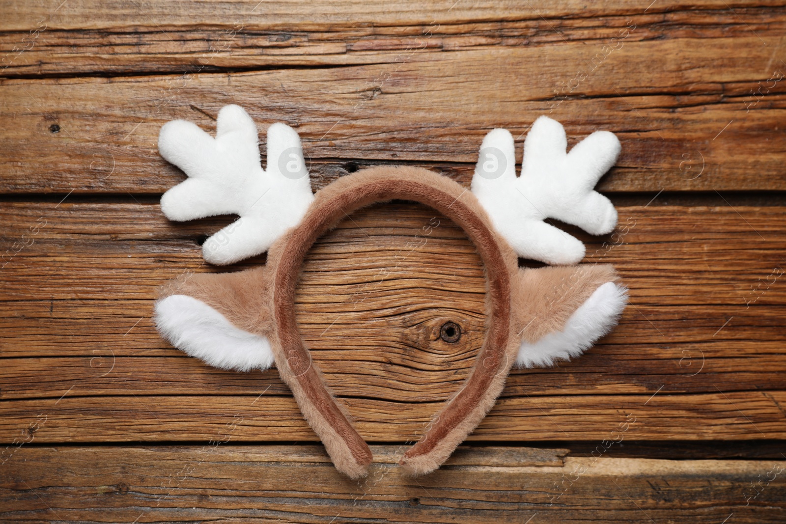 Photo of Beautiful reindeer headband on wooden background, top view. Christmas accessory