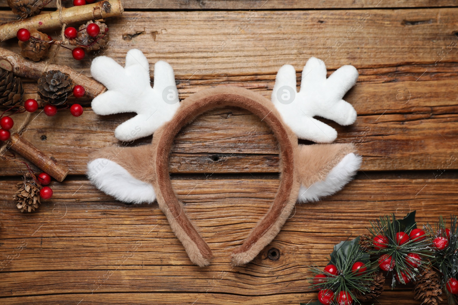 Photo of Beautiful reindeer headband and Christmas decor on wooden background, flat lay