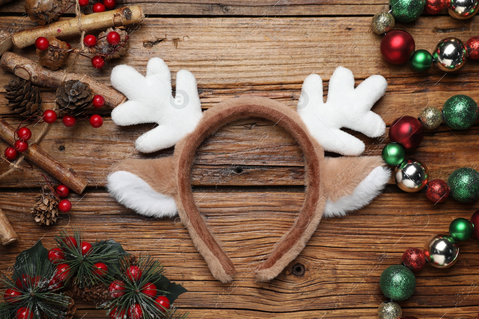 Photo of Beautiful reindeer headband and Christmas decor on wooden background, flat lay