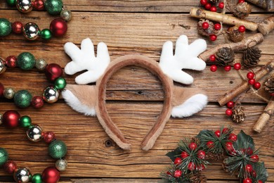 Photo of Beautiful reindeer headband and Christmas decor on wooden background, flat lay