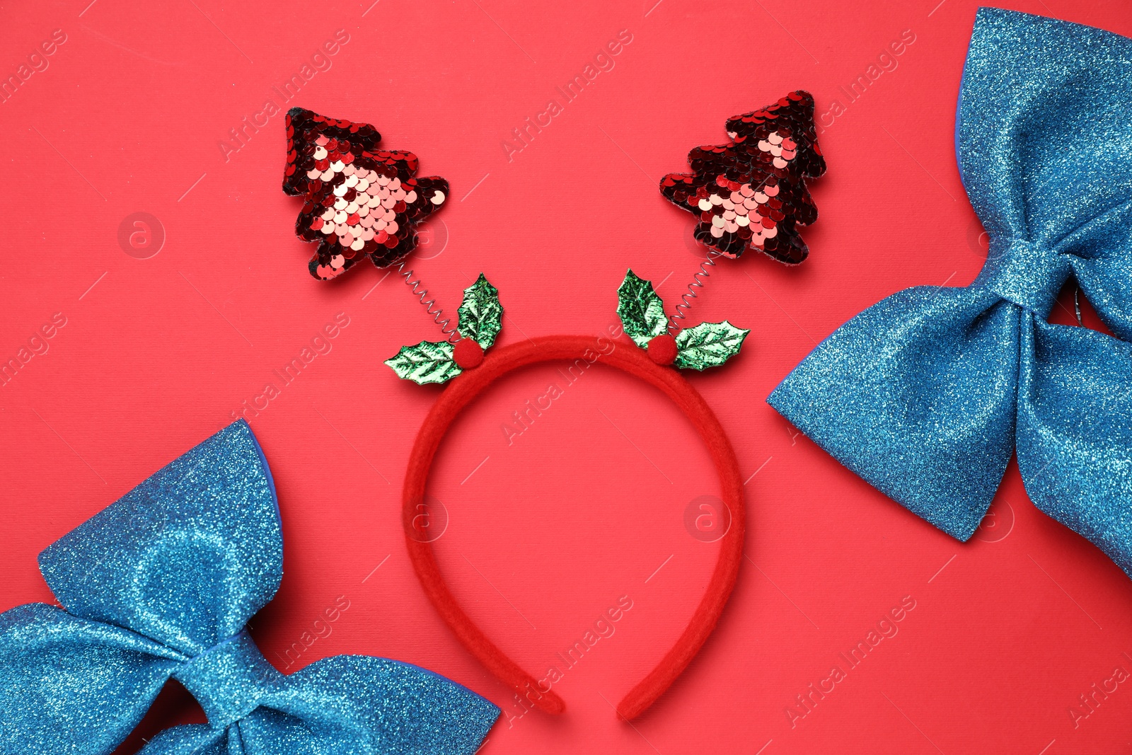 Photo of Stylish party headband and Christmas decor on red background, flat lay