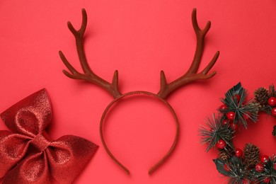 Photo of Beautiful reindeer headband and Christmas decor on red background, flat lay