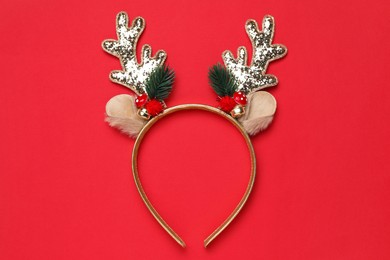 Photo of Beautiful reindeer headband on red background, top view. Christmas accessory