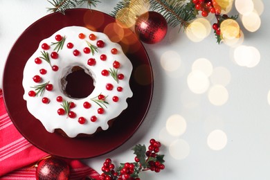 Photo of Traditional classic Christmas cake and decor on white table, flat lay with space for text. Bokeh effect