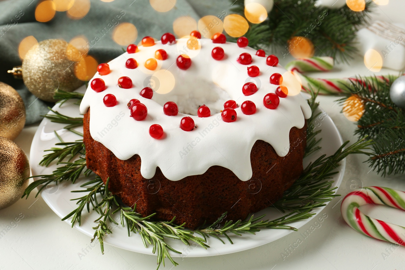 Photo of Traditional classic Christmas cake and decor on white table, closeup. Bokeh effect