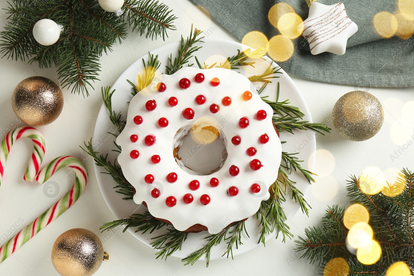 Photo of Traditional classic Christmas cake and decor on white table, flat lay. Bokeh effect