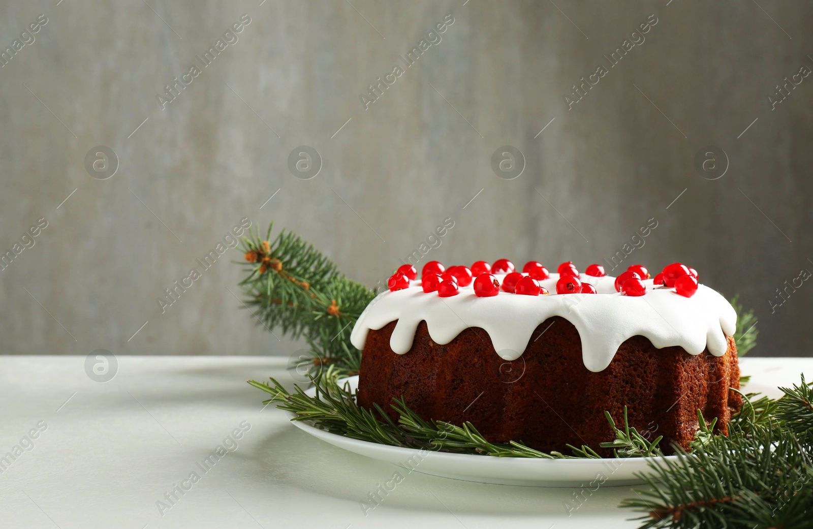 Photo of Beautifully decorated Christmas cake and fir branches on white table. Space for text