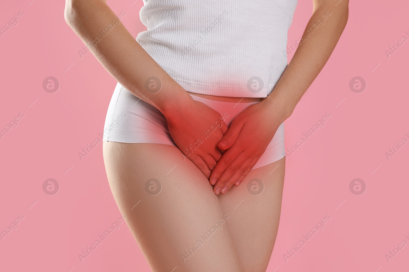 Image of STD (sexually transmitted diseases). Woman holding hands near her groin on pink background, closeup