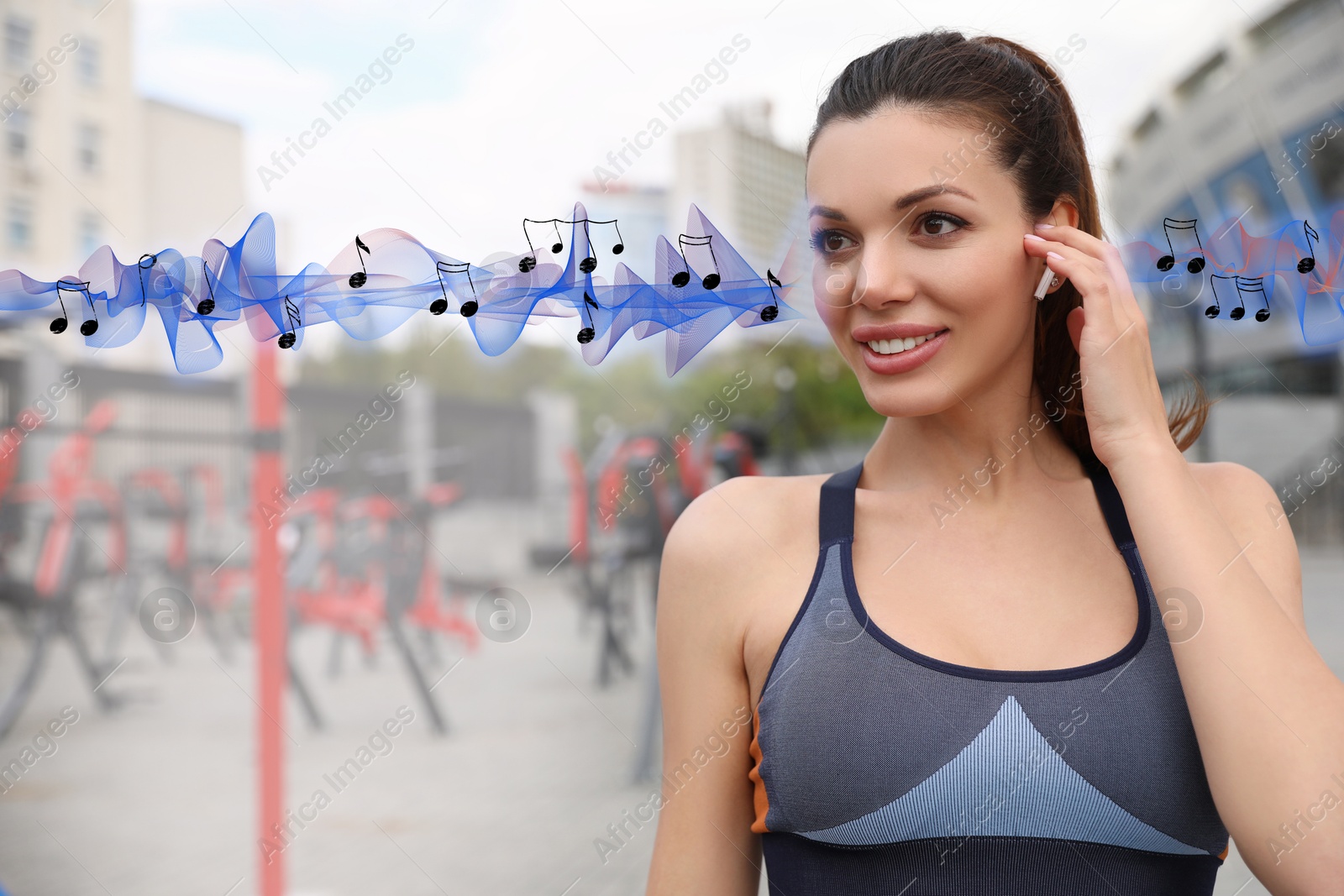 Image of Beautiful woman with earphones near outdoor gym. Music notes and sound waves near her