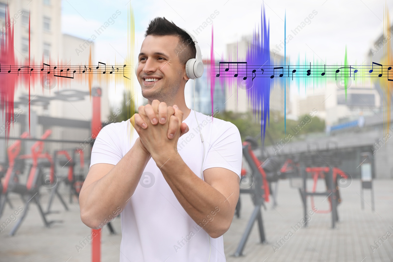 Image of Man with headphones doing exercise near outdoor gym. Music notes and sound waves near him