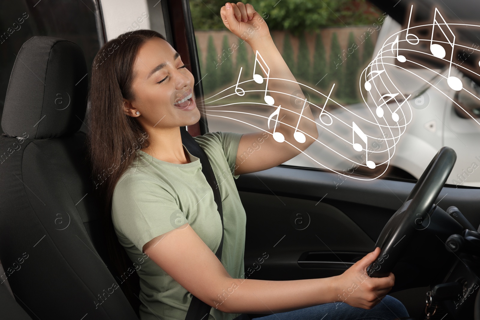 Image of Beautiful woman singing in car. Music notes flying out of her mouth