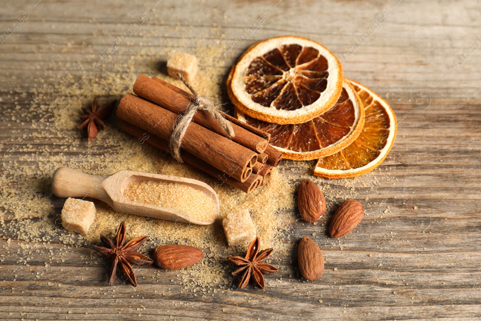 Photo of Different spices and dried orange slices on wooden table, above view. Christmas season