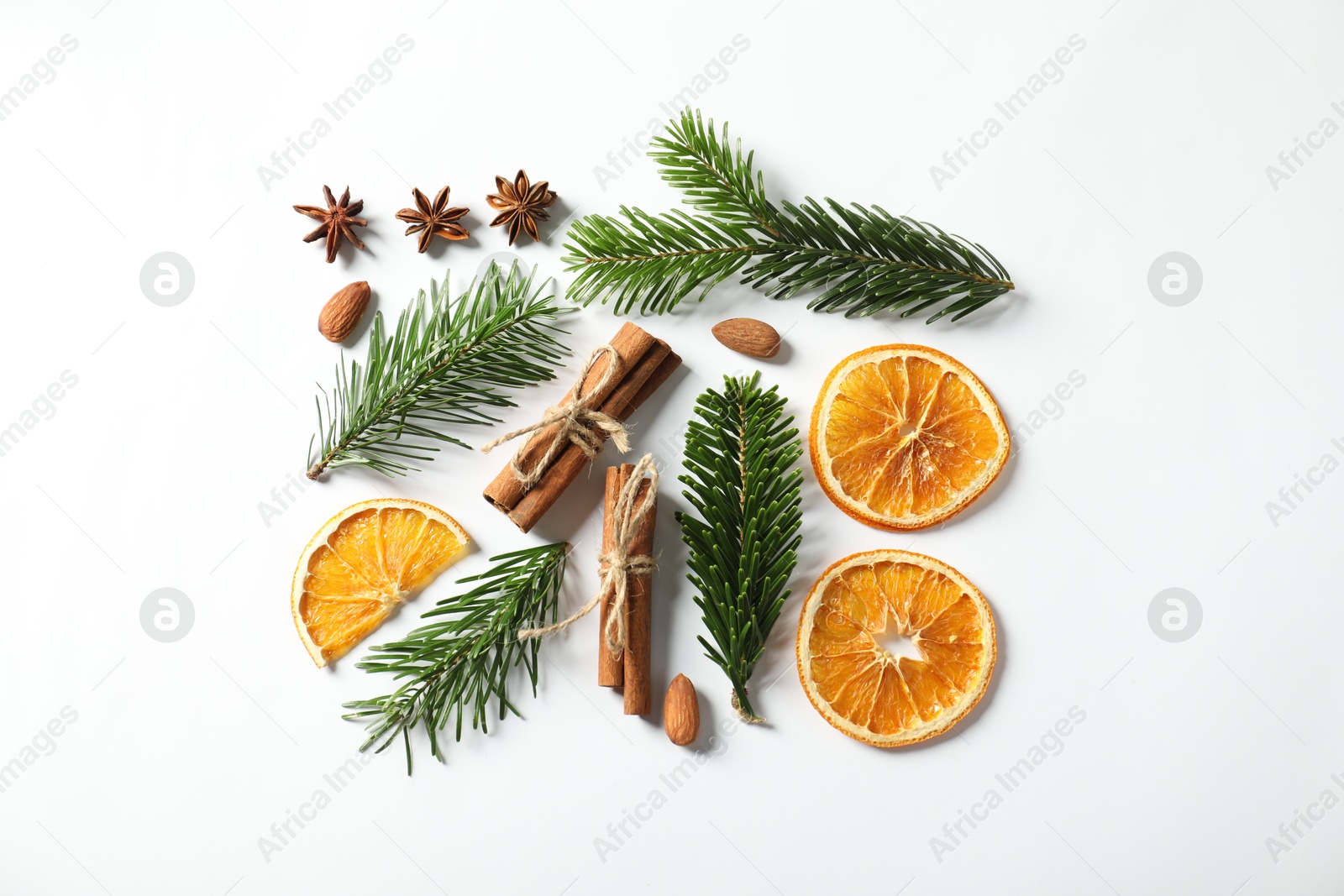 Photo of Different spices, dried orange slices and fir tree branches on white table, flat lay. Christmas season