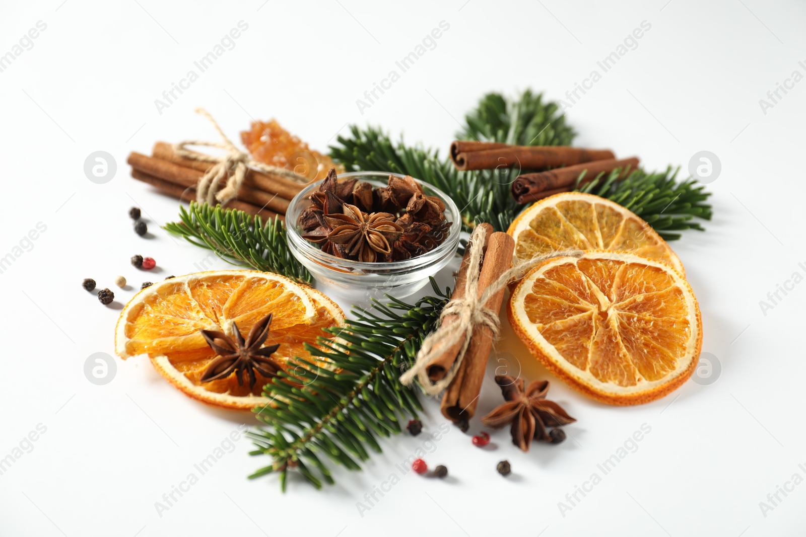 Photo of Different spices, dried orange slices and fir tree branches on white table. Christmas season