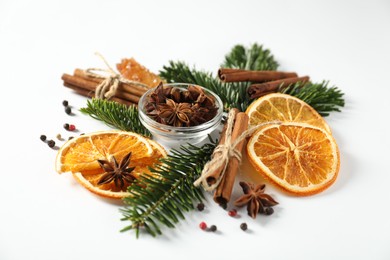 Photo of Different spices, dried orange slices and fir tree branches on white table. Christmas season