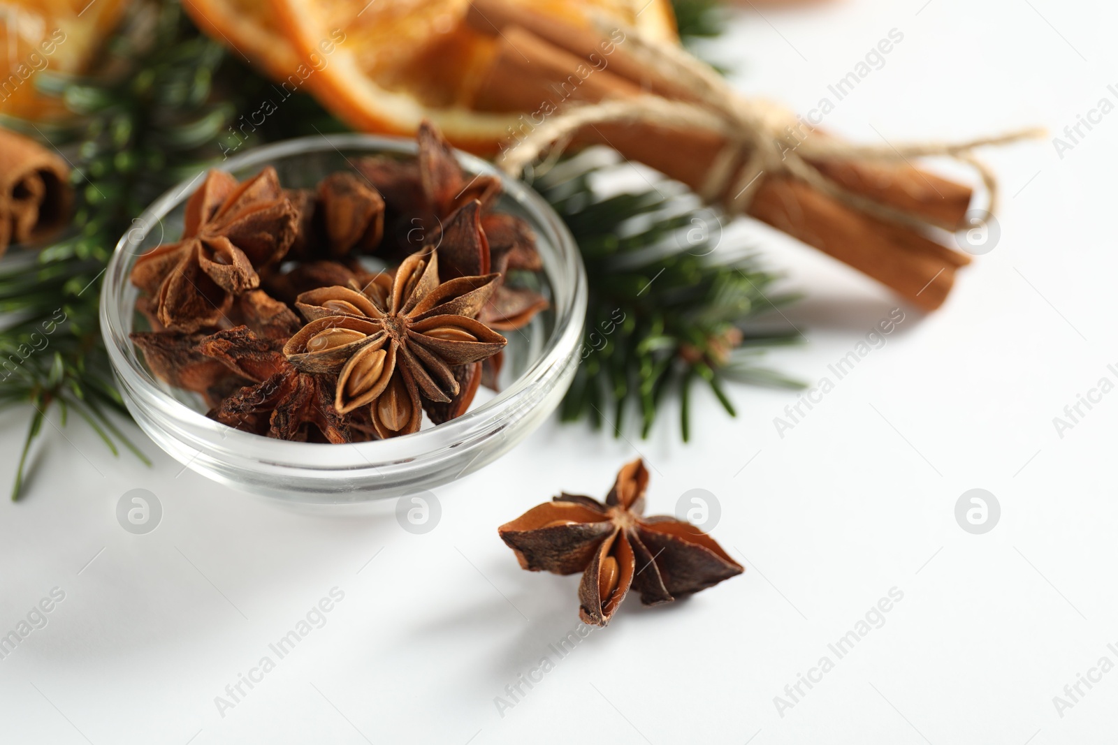 Photo of Different spices, dried orange slices and fir tree branches on white table, closeup. Christmas season