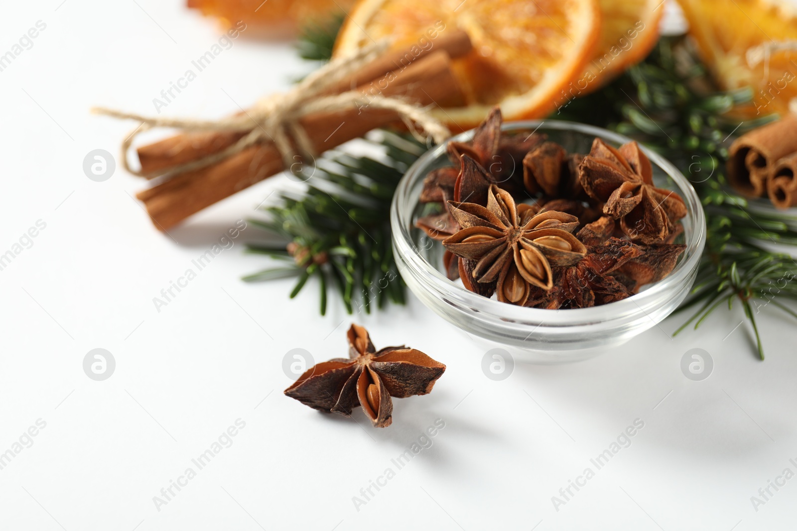 Photo of Different spices, dried orange slices and fir tree branches on white table, closeup. Christmas season