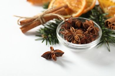 Photo of Different spices, dried orange slices and fir tree branches on white table, closeup. Christmas season