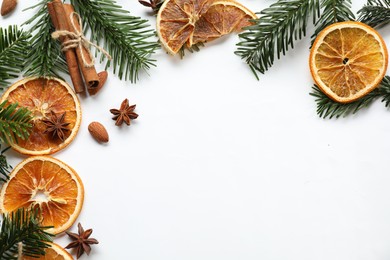 Photo of Different spices, dried orange slices and fir tree branches on white table, flat lay with space for text. Christmas season