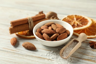 Photo of Different spices and dried orange slices on white wooden table, closeup. Christmas season