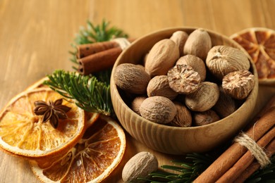 Photo of Different spices, dried orange slices and fir tree branches on wooden table, closeup. Christmas season