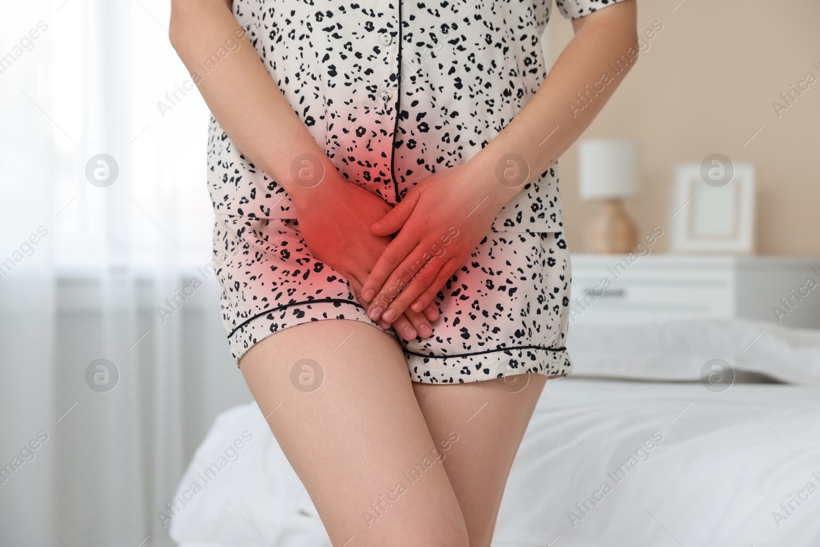 Image of STD (sexually transmitted diseases). Woman holding hands near her groin at home, closeup