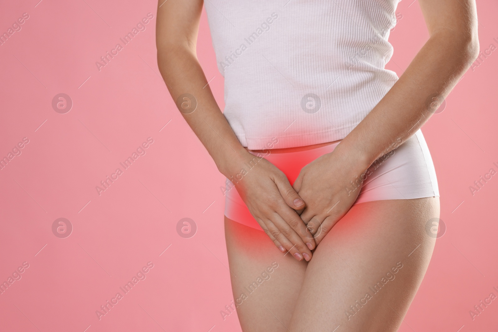 Image of STD (sexually transmitted diseases). Woman holding hands near her groin on pink background, closeup