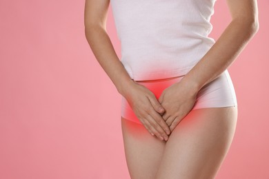 Image of STD (sexually transmitted diseases). Woman holding hands near her groin on pink background, closeup