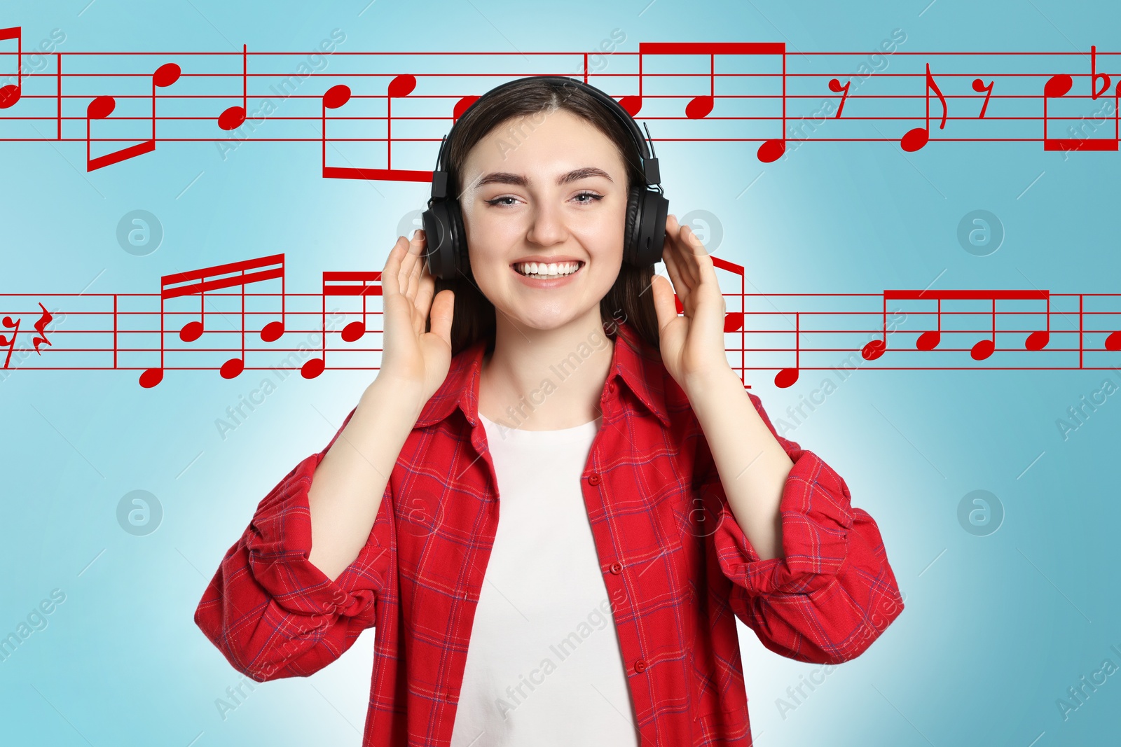 Image of Happy woman with headphones on light blue background. Music notes flying near her